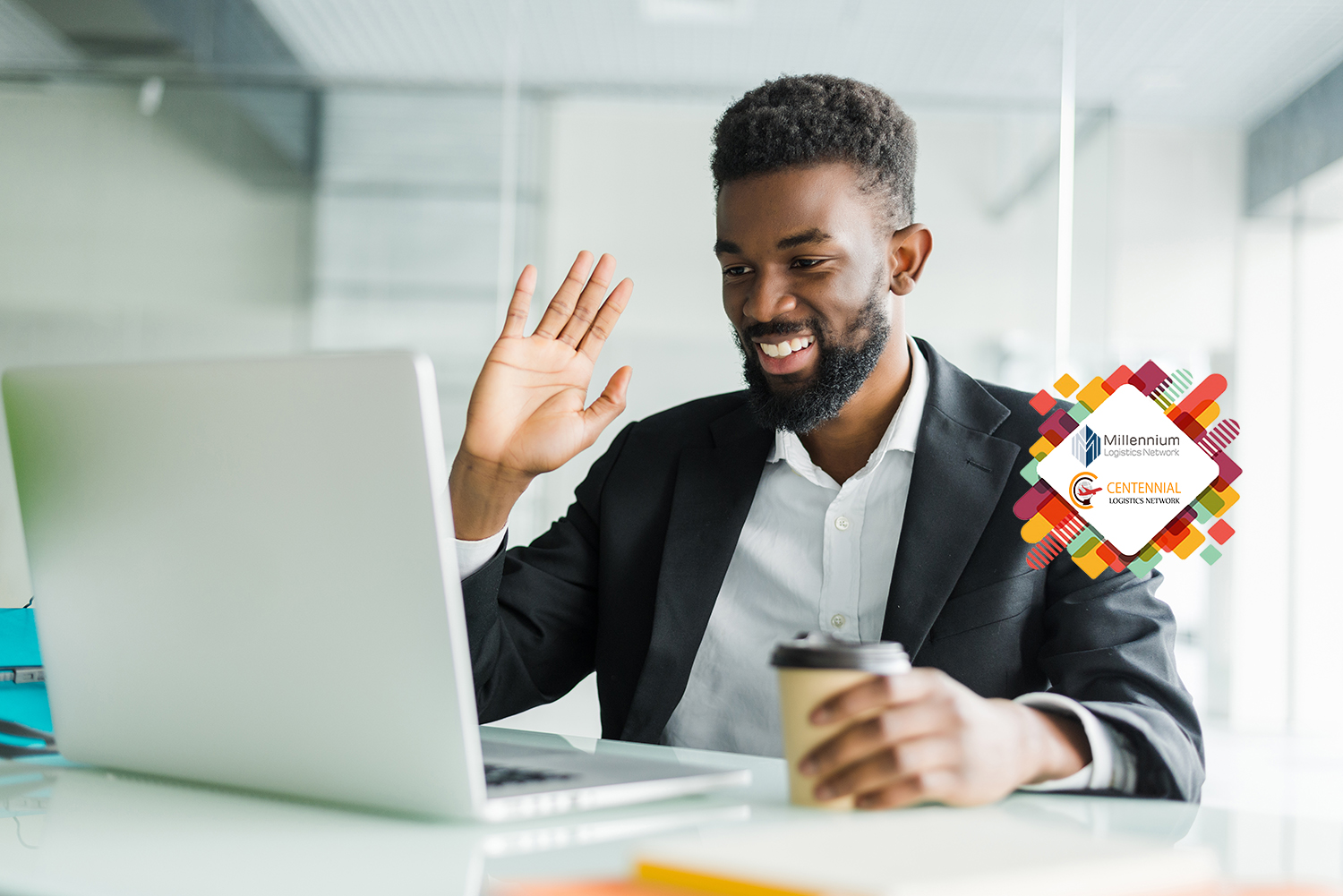 Young African manager with stubble sitting in front of open laptop wearing earphones while having video conference call with business partners